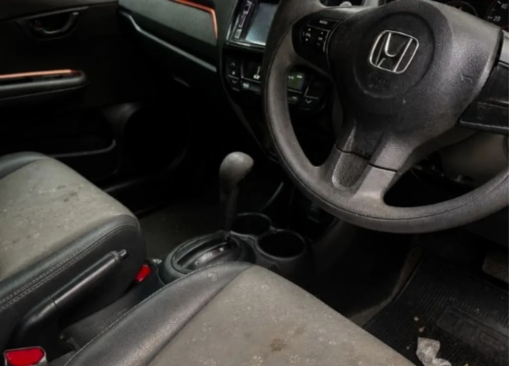 Interior mobil sebelum dibersihkan: jok kotor, debu di dashboard, dan karpet penuh kotoran.